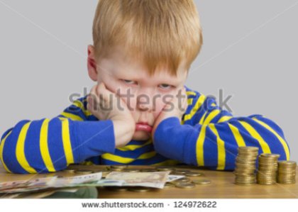 stock-photo-angry-boy-sitting-in-front-of-a-lot-of-money-124972622